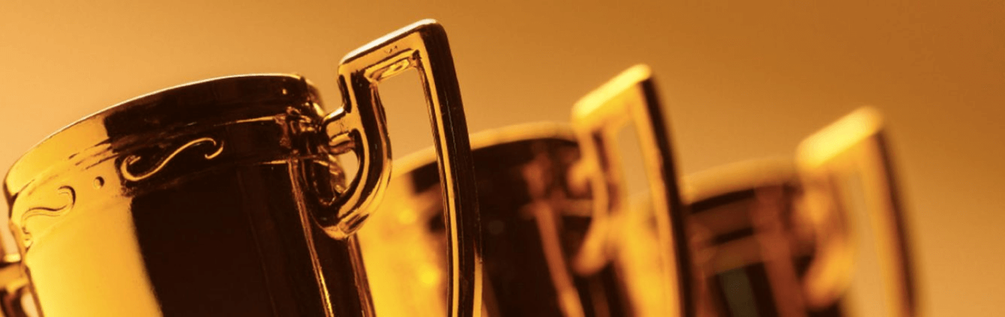 Close up shot of three trophy cups with a gold coloured overlay