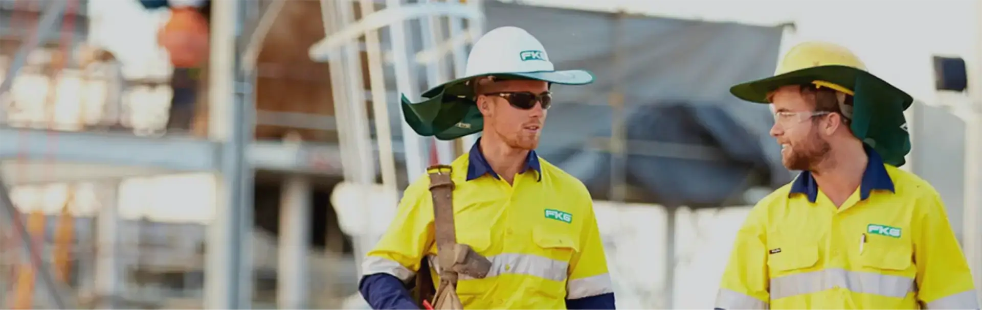 Two FKG personnel on site wearing high vis FKG branded uniforms and PPE